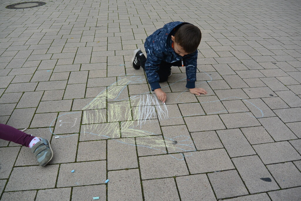Ein Kind malt mit Kreide